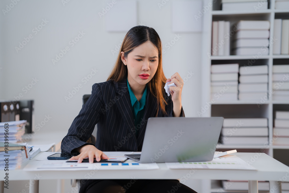 Overwhelmed and Stressed: Young Asian businesswoman cries at her desk, overwhelmed by work pressure and deadlines. Overwhelmed and Stressed: Young Asian businesswoman cries at her desk, overwhelmed by work pressure and deadlines.