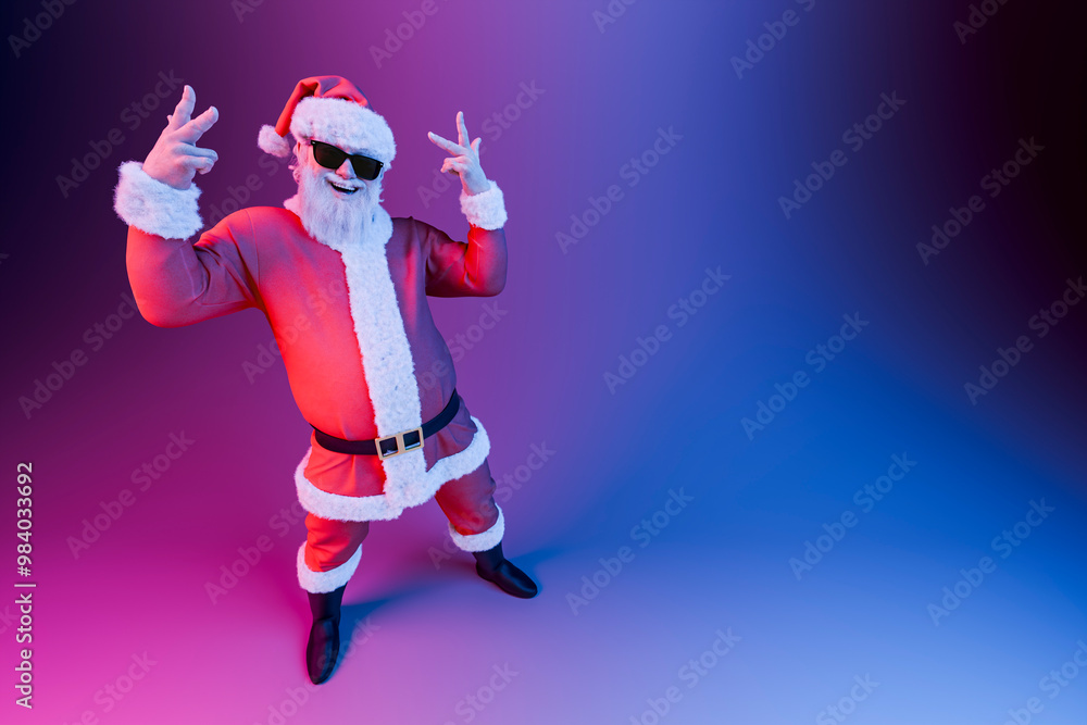 Santa claus wearing sunglasses is dancing under neon lights Santa claus wearing sunglasses is dancing under neon lights