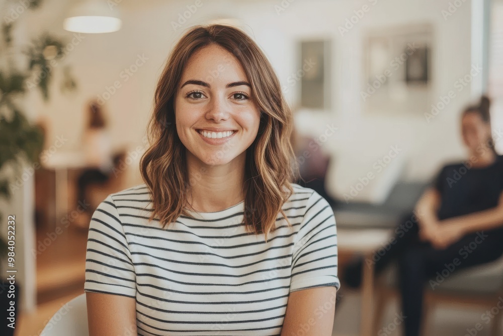 A confident woman sitting in a modern waiting area, smiling warmly at the camera A confident woman sitting in a modern waiting area, smiling warmly at the camera