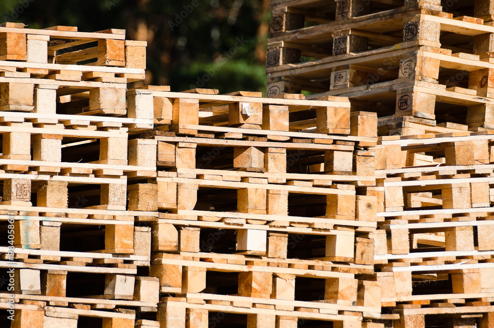 Riga, Latvia – August 10, 2024: stacks of wooden pallets close-up against green trees Riga, Latvia – August 10, 2024: stacks of wooden pallets close-up against green trees