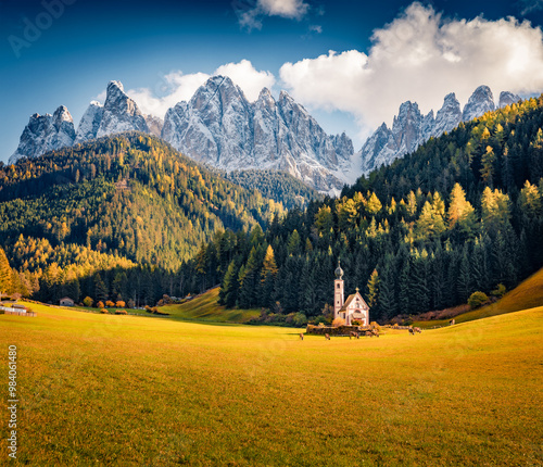 Dramatic autumn view of Chiesetta di San Giovanni in Ranui church in front of the Geisler or Odle Peak. Great morning scene of Dolomite Alps. Colorful. Beauty of countryside concept background..