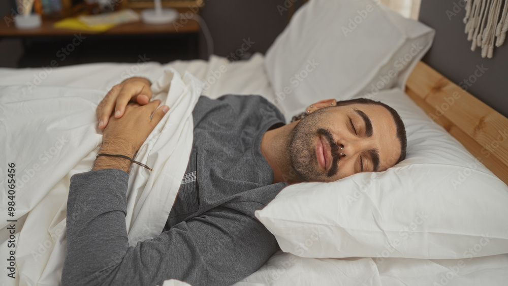 Handsome hispanic man with a moustache sleeping peacefully in a cozy bed inside a warmly lit bedroom with interior home decor. Handsome hispanic man with a moustache sleeping peacefully in a cozy bed inside a warmly lit bedroom with interior home decor.