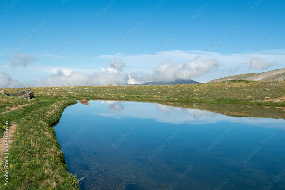 Reflection of clouds in the blue sky in the lake.Reflections in the glacial lake. Reflections on Kilimli lake. Lakes on top of Uludağ, Kilimli Lake, Bursa, Türkiye. Reflection of clouds in the blue sky in the lake.Reflections in the glacial lake. Reflections on Kilimli lake. Lakes on top of Uludağ, Kilimli Lake, Bursa, Türkiye.