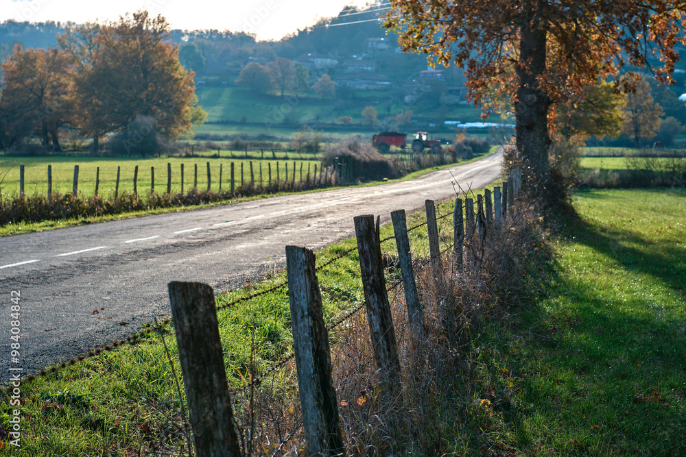 Rural road with wooden fence and autumn countryside Rural road with wooden fence and autumn countryside