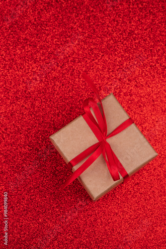 Gift box with a red bow seen from above on a bright red background. Gift and christmas concept photo