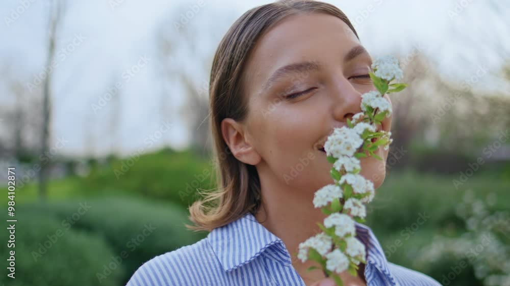 Closeup woman sniffing flowers scent smiling to camera in beautiful park.