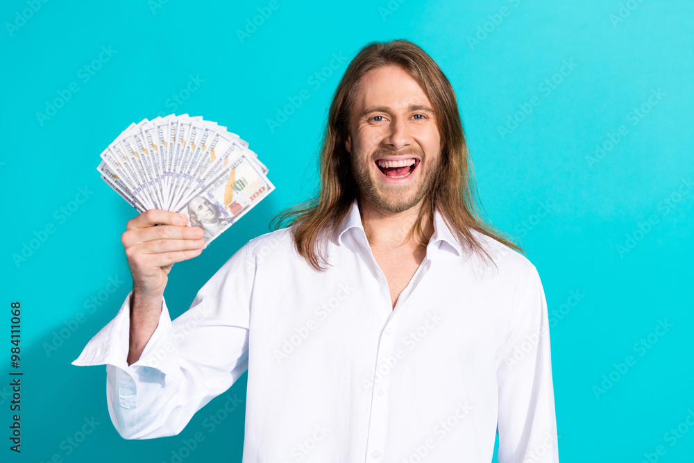 Photo of cheerful positive guy dressed white shirt showing cash fan emtpy space isolated turquoise color background Photo of cheerful positive guy dressed white shirt showing cash fan emtpy space isolated turquoise color background