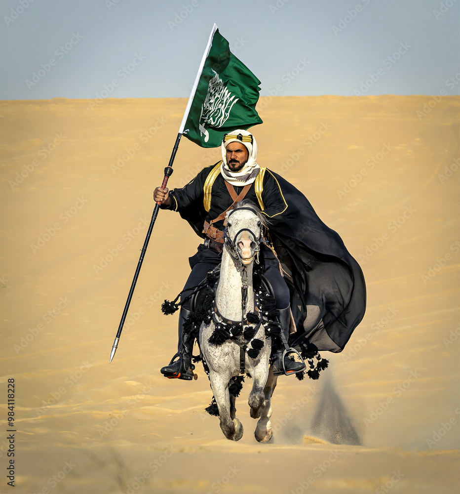 Naklejka premium Arabian Warrior, riding his white stallion with Saudi Arabian flag in the empt quarter desert