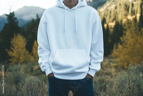 close-up photo of man wearing white blank hoodie mockup, standing in mountains 