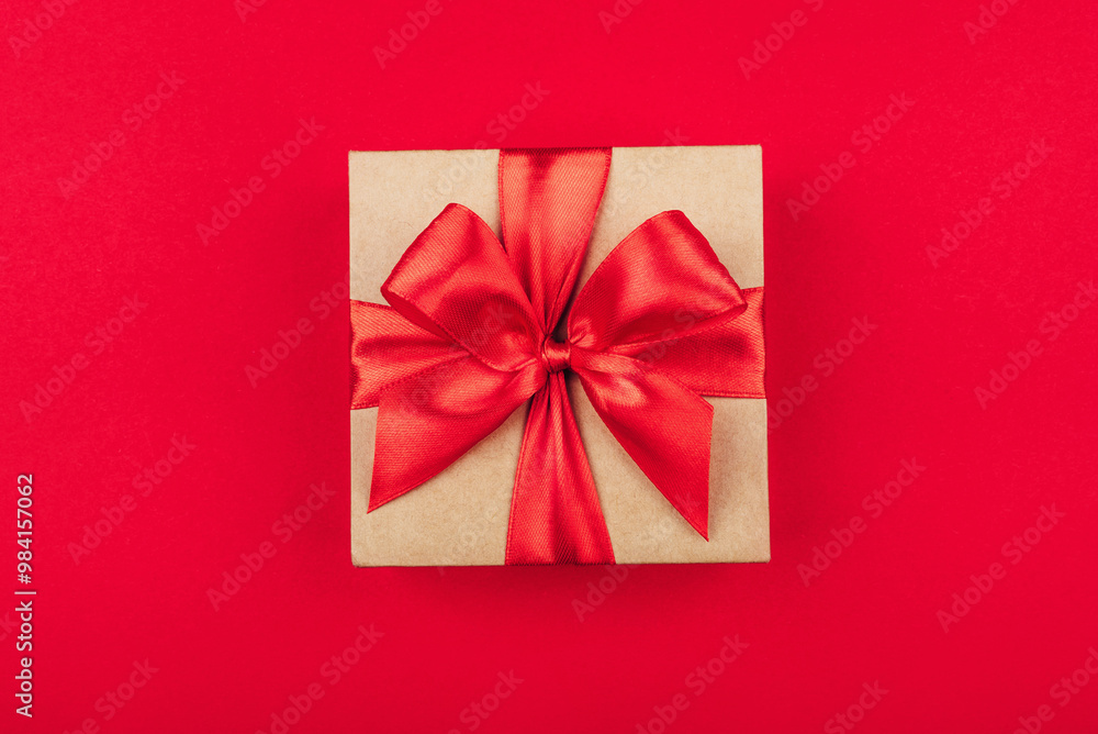 Cardboard gift box with bow on red background. Flat lay. Top view. Cardboard gift box with bow on red background. Flat lay. Top view.