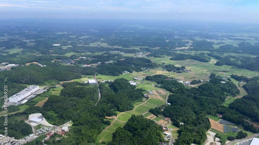 Green farmlands, industrial buildings, and forests on a clear sunny day, aerial view Green farmlands, industrial buildings, and forests on a clear sunny day, aerial view