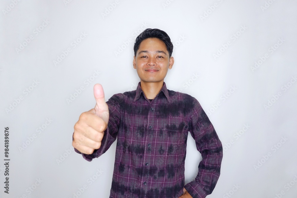 Portrait of a handsome Indonesian man in a purple flannel shirt, posing randomly on an isolated white background Portrait of a handsome Indonesian man in a purple flannel shirt, posing randomly on an isolated white background