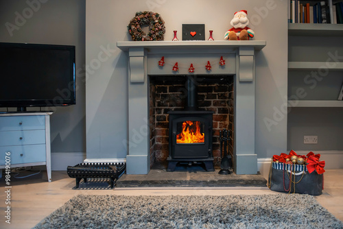 box with Christmas decorations near fireplace with fire, preparation for Christmas photo