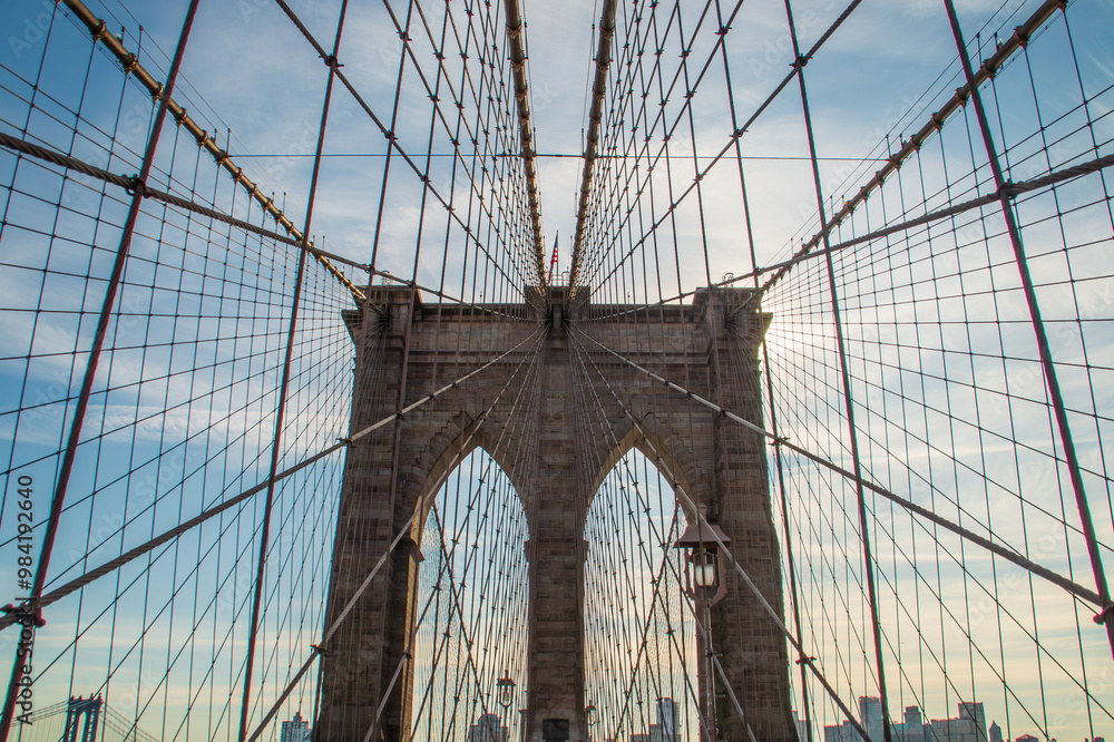 Fototapeta premium Detalles arquitectónicos del famoso puente de Brooklyn en New York, USA. Cableado y arcos de piedra vistos desde abajo, desde el paso peatonal, en uno de sus dos pilares, el más cercano a Manhattan.