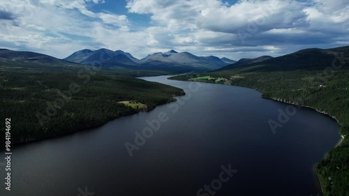 Drone flying over the Atnsjøen lake, with majestic mountain peaks Storronden, Rondslottet and Høgronden in Rondane National Park Innlandet Norway.