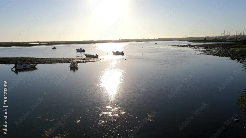 Small boats silhouetted against the sunset on a polluted river Small boats silhouetted against the sunset on a polluted river