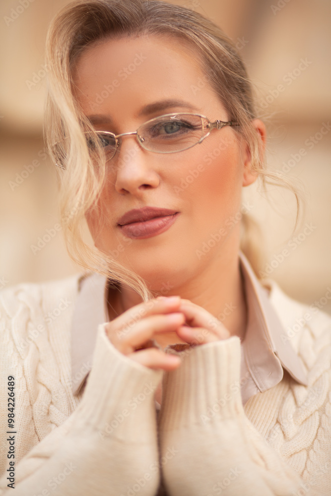 The portrait of the blond woman plus the site is stylishly dressed in pastel clothes, a beige knitting blazer, glasses, a skirt and a silk blouse walks down the street The portrait of the blond woman plus the site is stylishly dressed in pastel clothes, a beige knitting blazer, glasses, a skirt and a silk blouse walks down the street