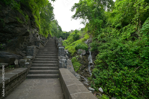 Man made stone stairway amidst lush green forest ascending from Lonar crater situated in Maharashtra, India.