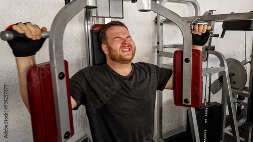 Bilde på lerret Caucasian man straining on gym equipment, symbolizing the struggle and determina