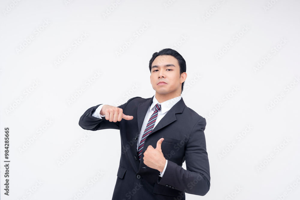 A cocky and insecure young asian business executive pointing to himself,making thumbs up sign. Isolated on a white background. A cocky and insecure young asian business executive pointing to himself,making thumbs up sign. Isolated on a white background.