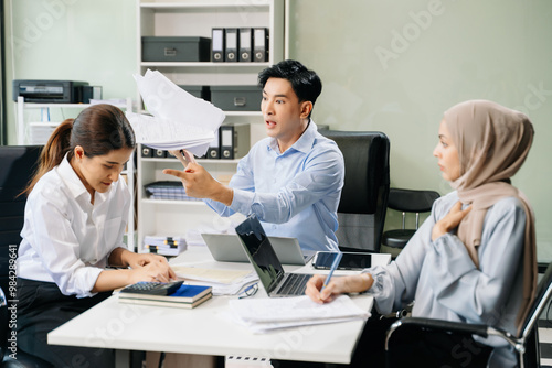 Furious two Asian businesspeople arguing strongly after making a mistake at work