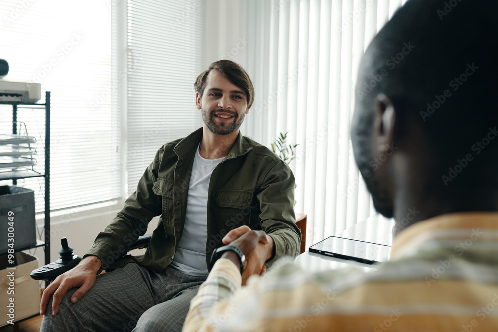 Businessman with disability greeting his colleague at meeting Businessman with disability greeting his colleague at meeting