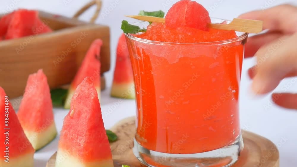 hand pick up a glass of refreshing watermelon smoothies with mint for summer drink, isolated in white hand pick up a glass of refreshing watermelon smoothies with mint for summer drink, isolated in white