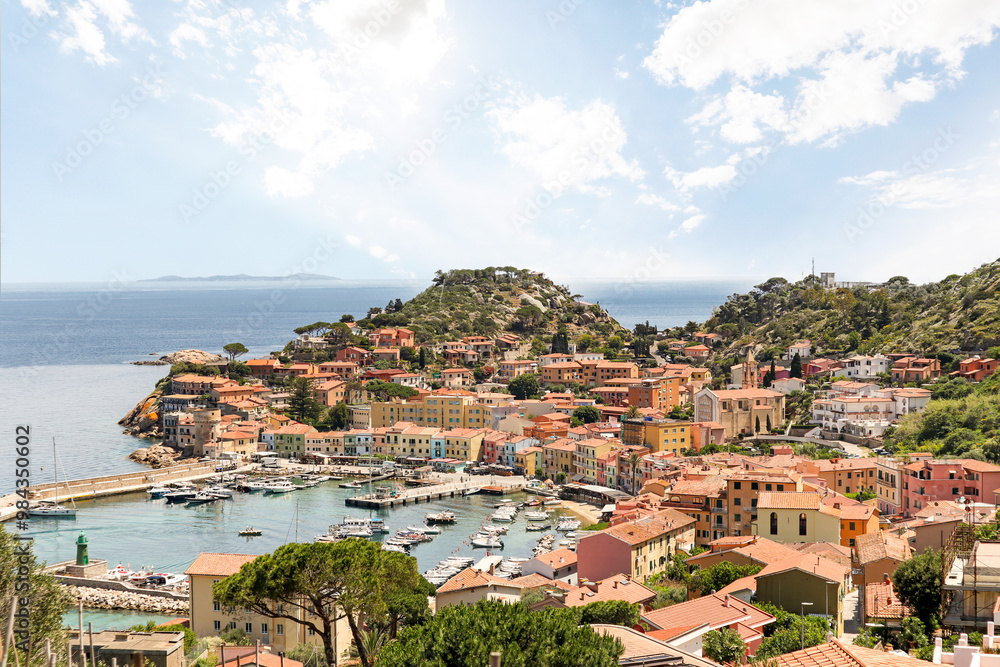 Obraz premium View to harbour and old town of Giglio Porto at Isola del Giglio, island of the tuscan archipelago, beautiful ancient rustico buildings and ferry terminal to Porto San Stefano, Grosseto Tuscany Italy