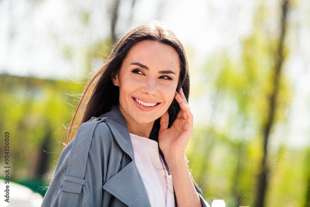 Portrait photo of beautiful young smiling adorable latin attractive lady dreaming wearing gray coat walking outdoors relaxed in nature Portrait photo of beautiful young smiling adorable latin attractive lady dreaming wearing gray coat walking outdoors relaxed in nature