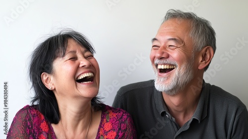 A joyful couple sharing a heartfelt laughter, their faces radiating happiness against a minimalist white background with a subtle Gaussian blur effect, highlighting the pure emotion of the moment.