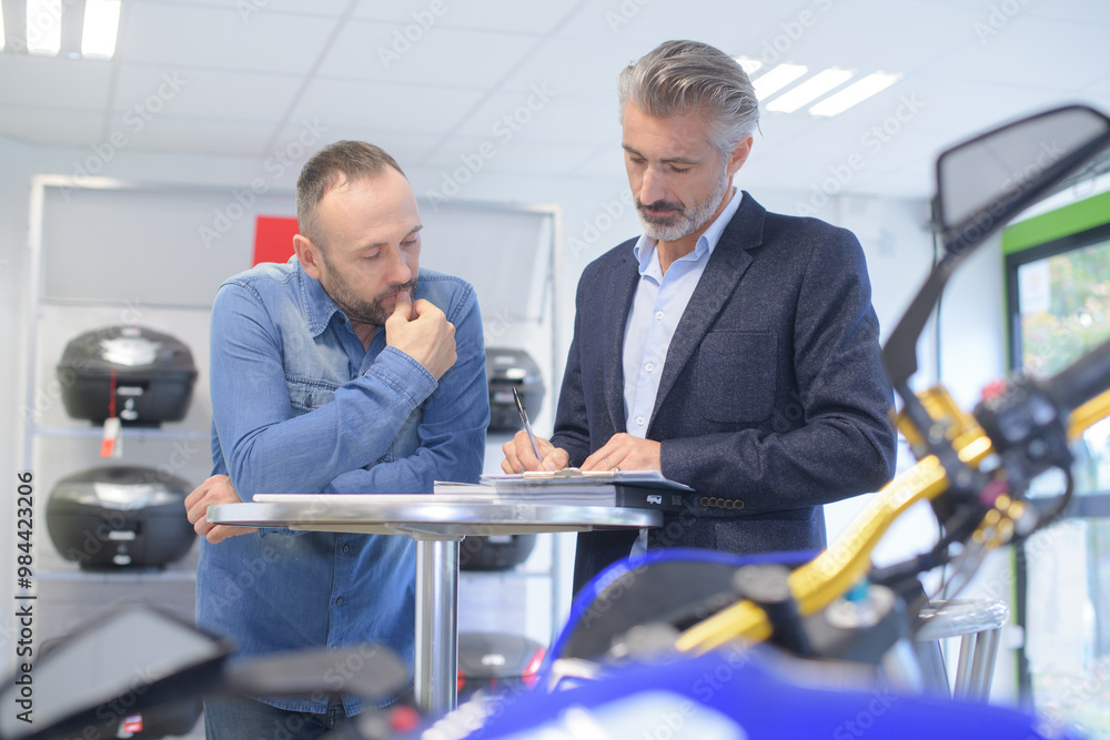 © auremar - male seller writing selling contract with handsome customer