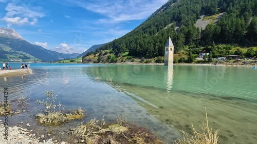 View of Lake Resia - Italy where you can admire the famous bell tower of the submerged church emerging from the water. photo