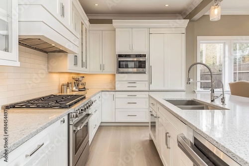 A contemporary kitchen in white featuring stainless steel appliances, a spacious island, and a mix of light fixtures, perfect for culinary endeavors and family gatherings. photo