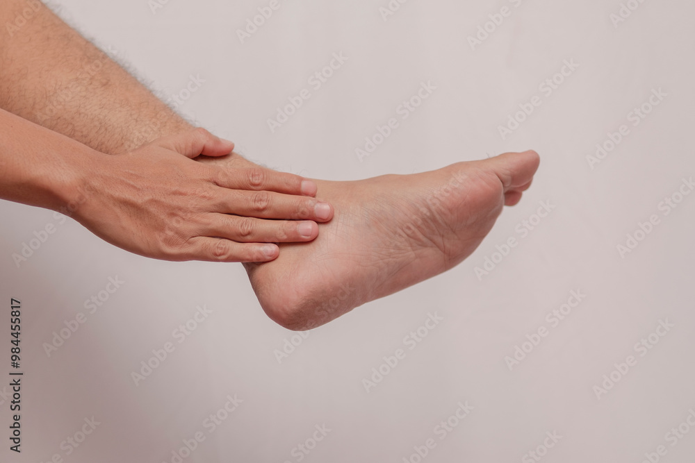 Fototapeta premium A man's leg suffers from gout. The feet experience inflammation of the feet which are held by the hands. health concept on foot inflammation.