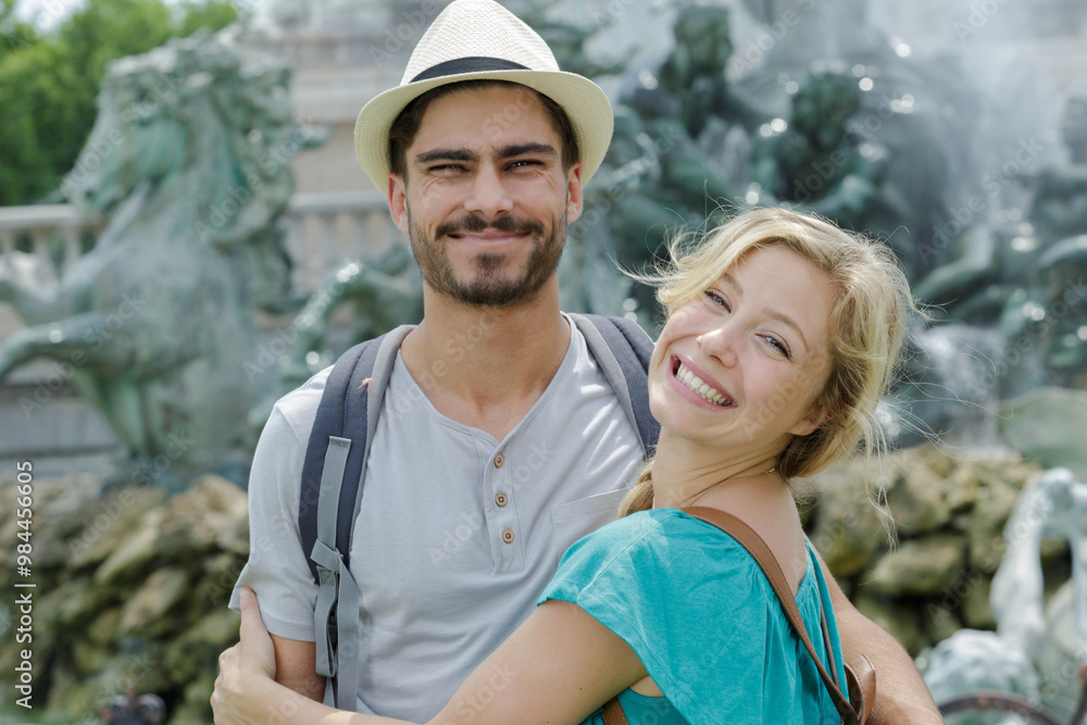 grinning couple posing by tourist landmark grinning couple posing by tourist landmark