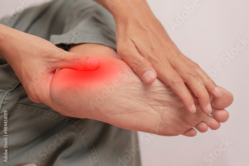 Inflammation of the ankle held by hand. Pain attacks a young man's ankle. health concept on leg bones.Ankle pain holding his aching leg - body pain concept.