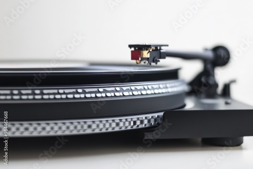 This image is a close-up view of a turntable's needle and platter, capturing the texture and detail of a vinyl record in motion. A classic representation of analog music. photo