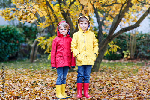 Two little best friends and kids boys autumn park in colorful cl