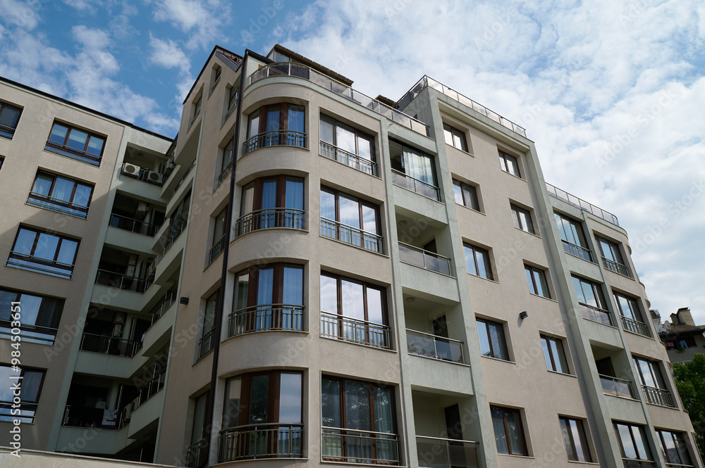 Modern residential building showcasing curved balcony design in a vibrant urban neighborhood under a bright sky, Varna, Bulgaria