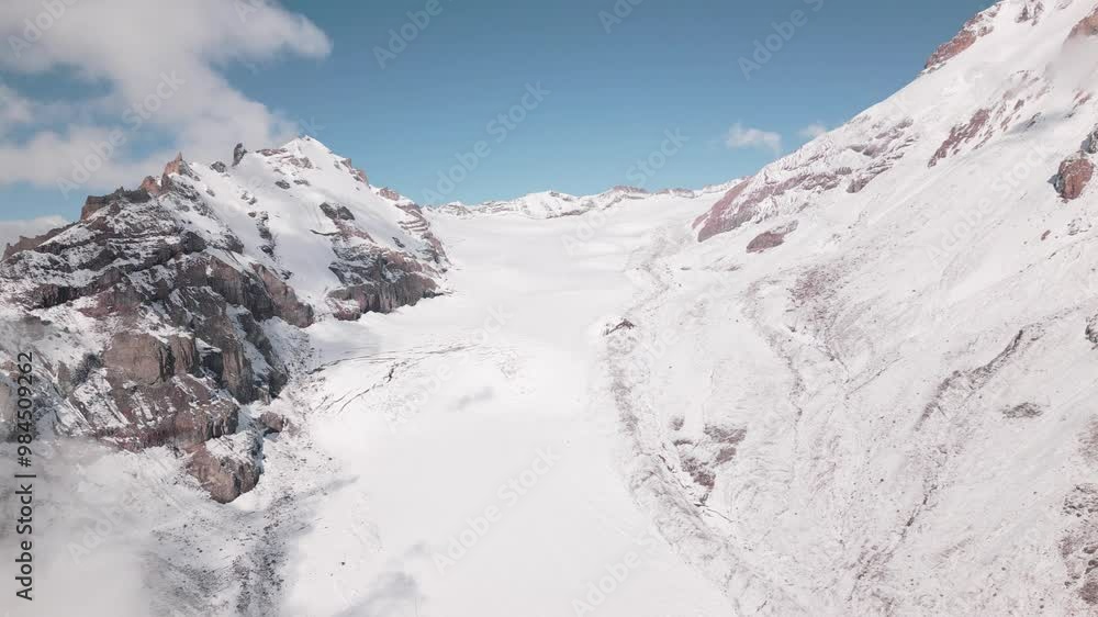 Aerial view close up Gergeti glacier tongue located on the southeastern slope of Mt. Kazbek. Kazbegi District of Georgia. Mount Kazbek climbing route. Caucasus mountain range snowy peaks Aerial view close up Gergeti glacier tongue located on the southeastern slope of Mt. Kazbek. Kazbegi District of Georgia. Mount Kazbek climbing route. Caucasus mountain range snowy peaks