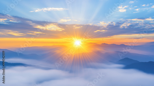 Golden sunrise over a misty, layered mountain landscape.