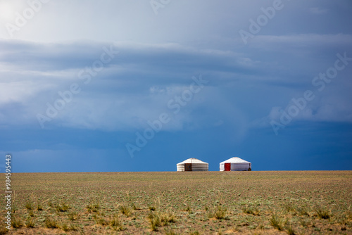 two yurts on the hill next to each other with blue sky photo