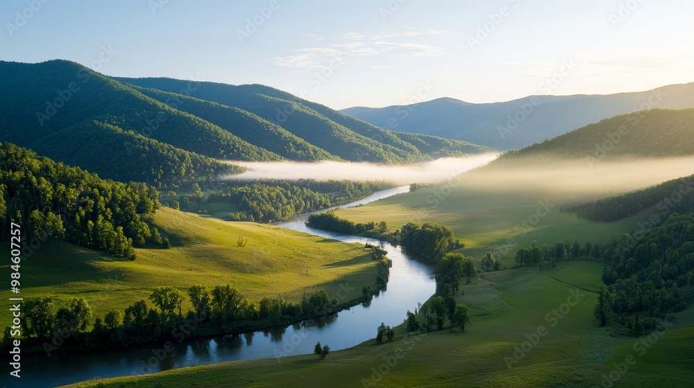 Obraz premium A valley waking to the morning sun, the light reflecting off the river and lighting up the meadows and hillside.