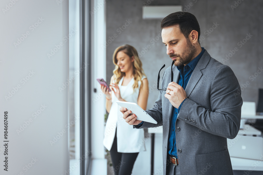 Business Professionals Using Digital Devices in Modern Office Environment Business Professionals Using Digital Devices in Modern Office Environment