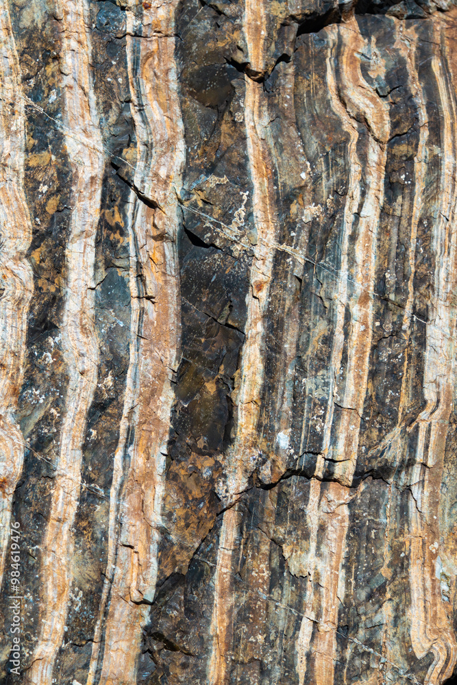 The texture of granite stone with cracks and stripes, made in various shades of brown. The stripes give the stone additional depth and character, emphasizing the natural features of the material.