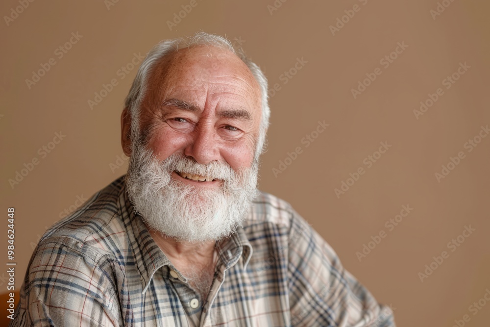 A senior man wearing a checked shirt shares a joyful smile A senior man wearing a checked shirt shares a joyful smile