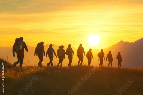 A group of hikers, consisting of parents and children, walks together at sunrise to celebrate the summer solstice, with the sky ablaze in golden light.