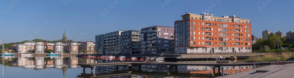 Panorama view, the district Hammarby sjöstad, boats, the district Södermalm, piers, boats, commuting ferries and apartment houses, a sunny summer day in Stockholm Panorama view, the district Hammarby sjöstad, boats, the district Södermalm, piers, boats, commuting ferries and apartment houses, a sunny summer day in Stockholm