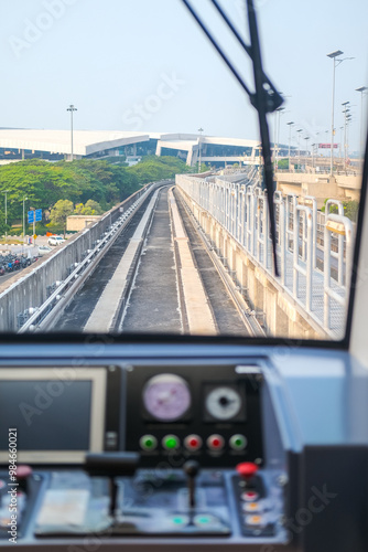 Obraz na płótnie View from inside airport train shows tracks curving ahead through a tunnel, with control panel in foreground, capturing the smooth journey and modern transit experience. w salonie