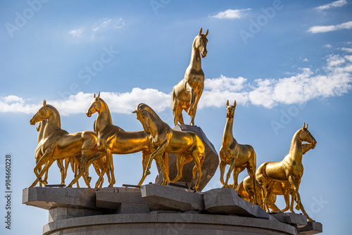 Bild auf Leinwand golden horses herd statue turkmenistan blue sky